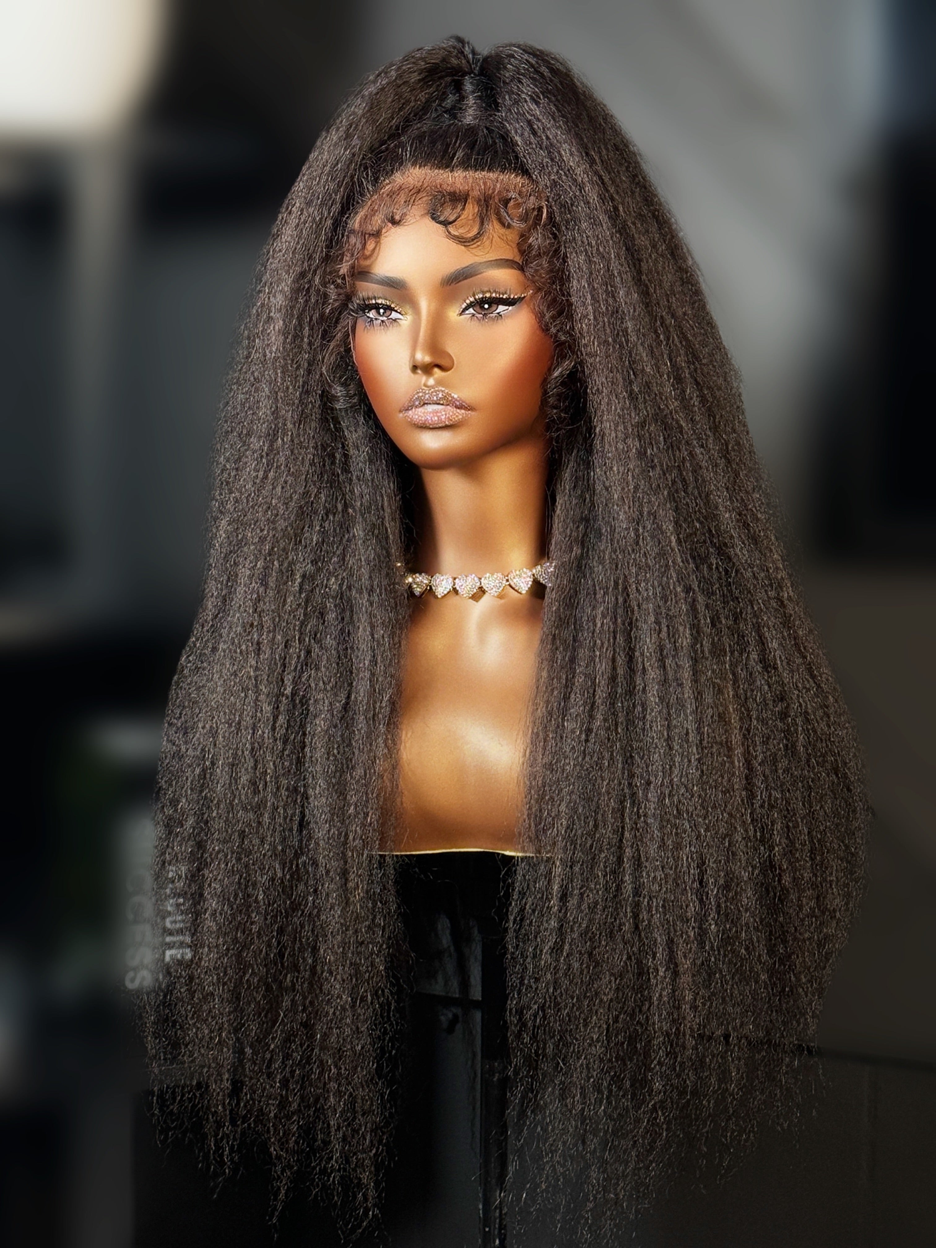 Mannequin head with long, styled hair on a blurred background