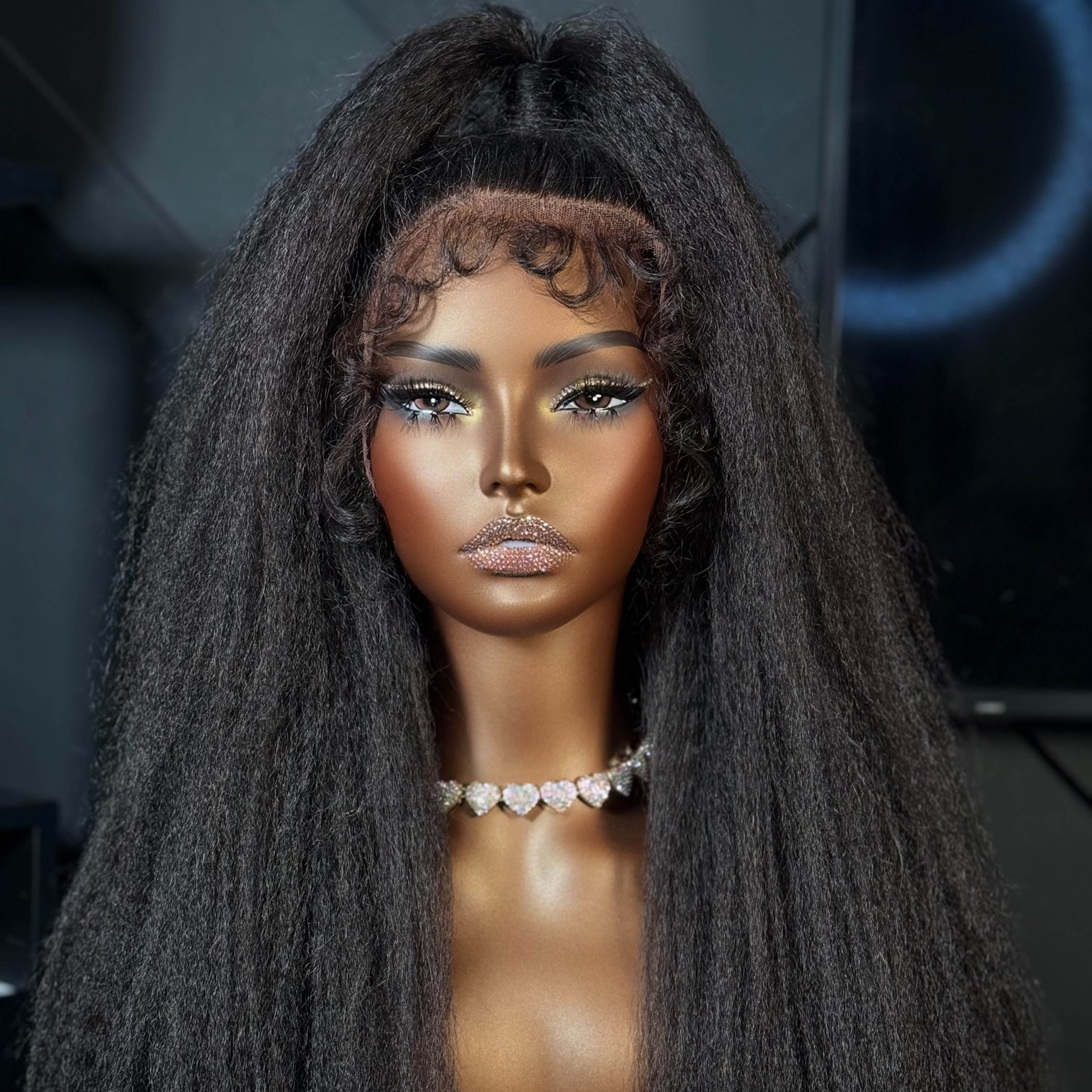 Mannequin head with long black hair against a dark background