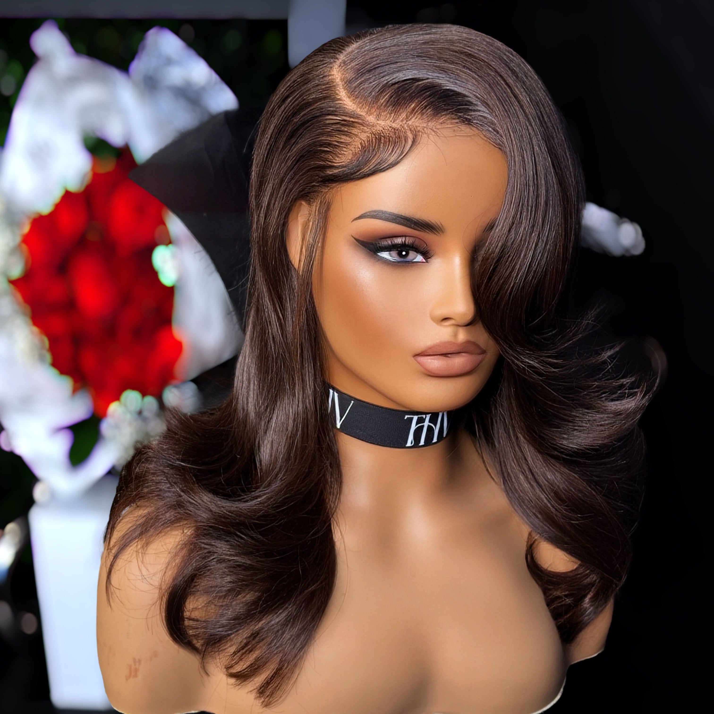 Mannequin head with a brown wig on a blurred floral background