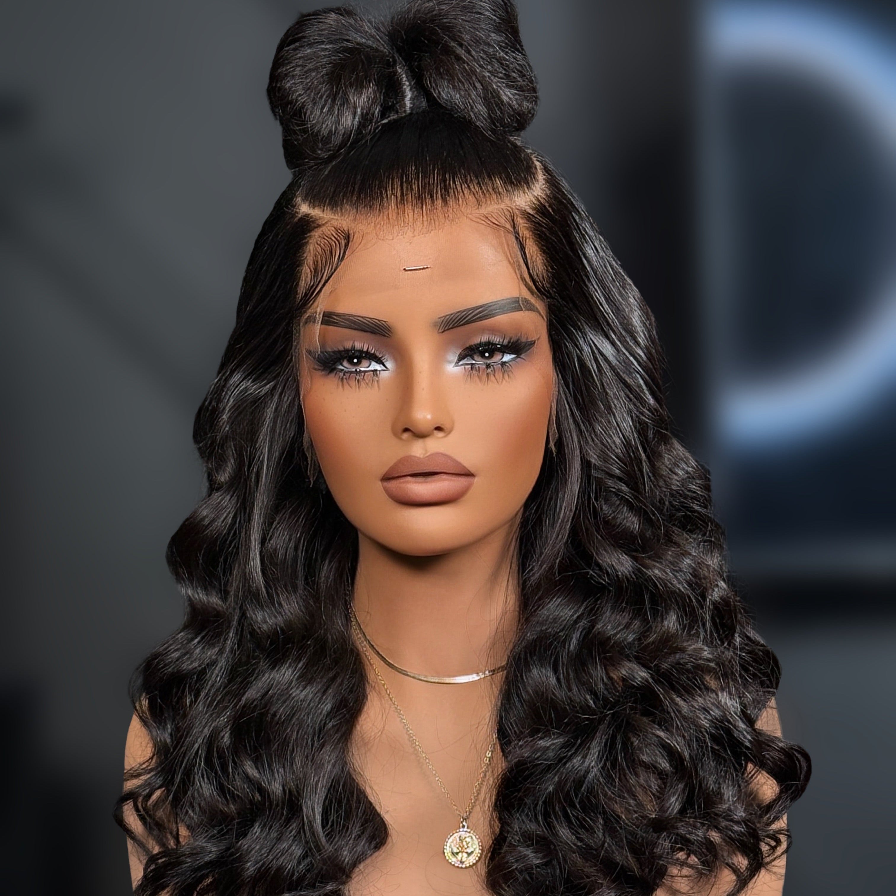 Mannequin head with long, wavy black hair styled with a large bow on a dark background