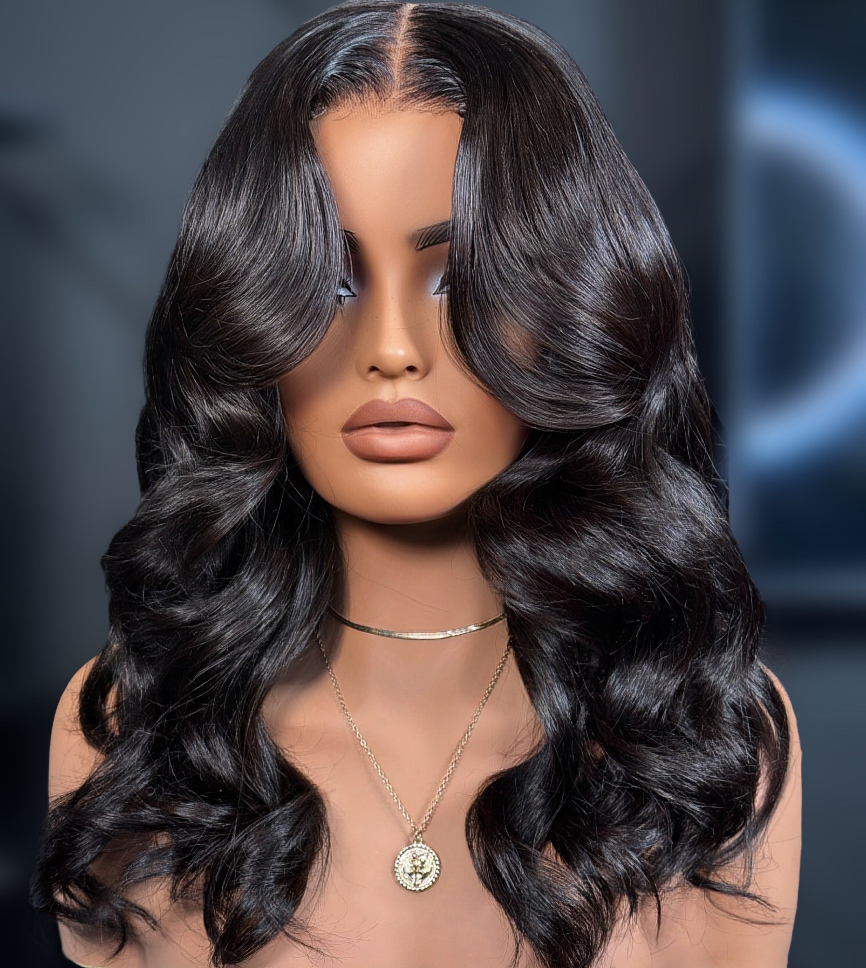 Mannequin head with long, wavy black hair on a dark background