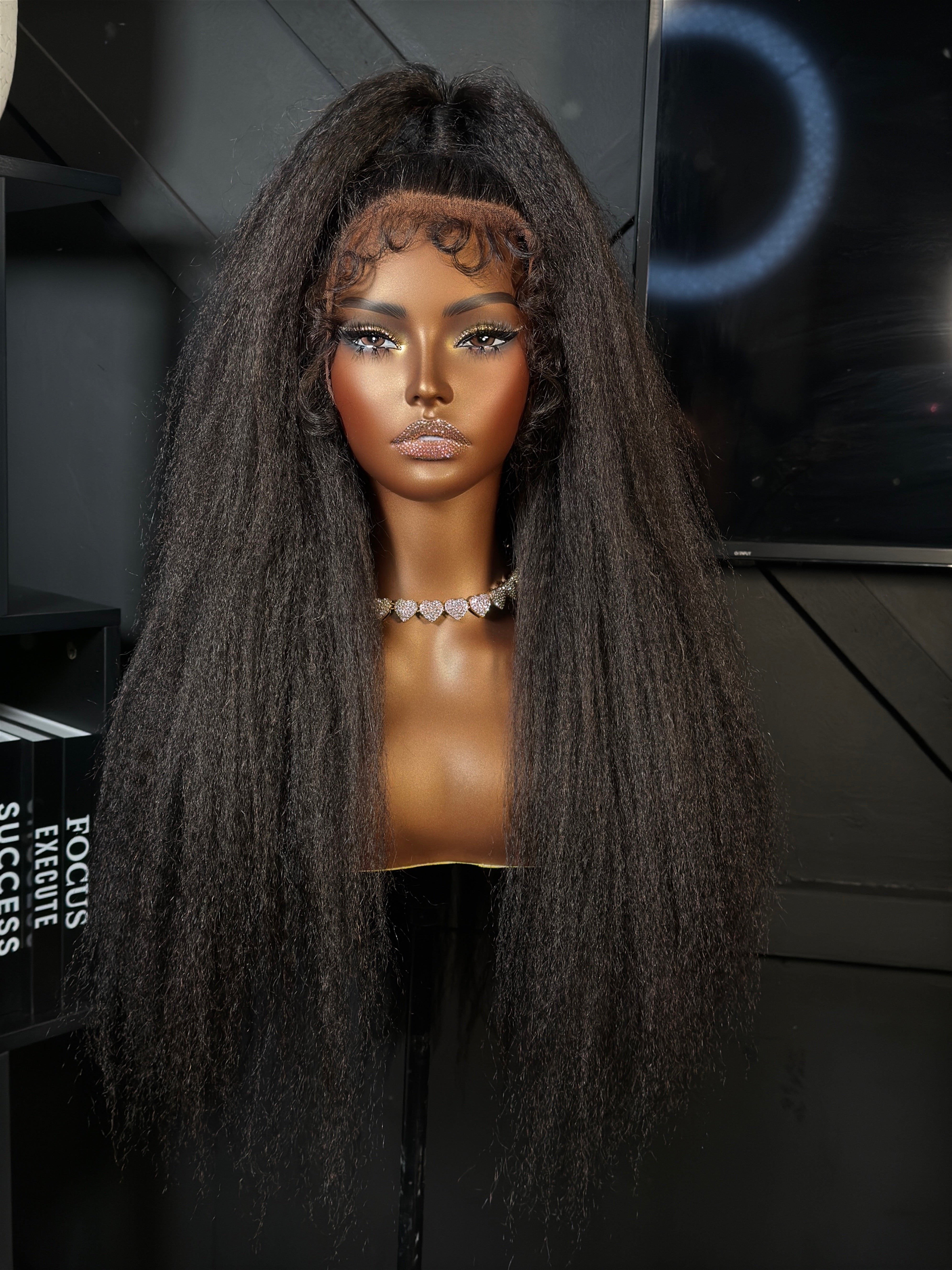 Mannequin head with long, dark brown hair against a dark background